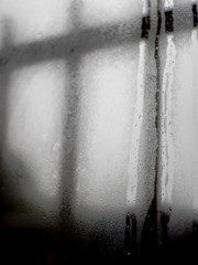 Raindrops sliding down window on cold winter day