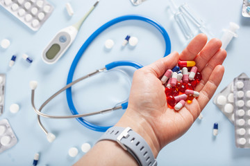 hand holding pills, stethoscope syringe capsule medicine. medical treatment for flu virus