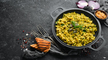Pasta with pesto sauce, instant cooking in a frying pan. Top view. Free space for your text. Rustic style.