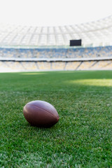 rugby ball on green grass at stadium with copy space