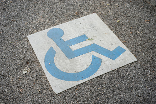 Closeup of painted blue symbol of invalid area parking in the street