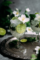 Cold cocktail with mint, lime and ice in a glass