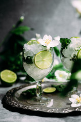 Cold cocktail with mint, lime and ice in a glass