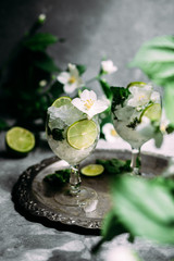 Cold cocktail with mint, lime and ice in a glass