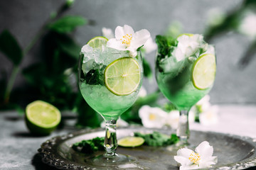 Cold cocktail with mint, lime and ice in a glass