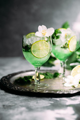 Cold cocktail with mint, lime and ice in a glass