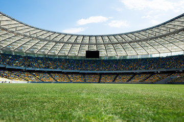 grassy football pitch at stadium at sunny day with blue sky - obrazy, fototapety, plakaty