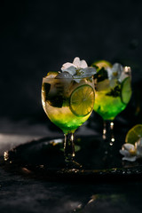 Cold cocktail with mint, lime and ice in a glass