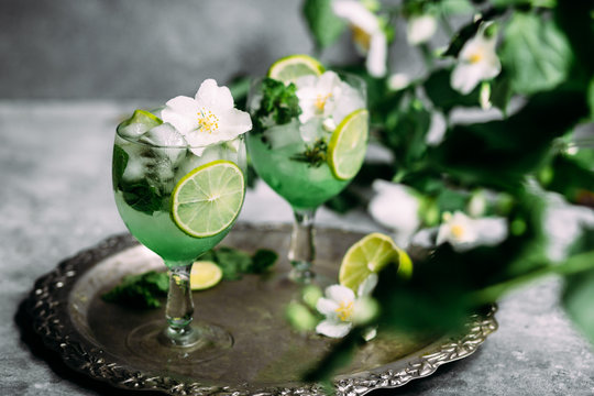 Cold cocktail with mint, lime and ice in a glass