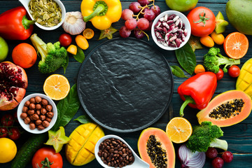 Background Organic food. Fruits, vegetables, beans and nuts on a blue background. Top view. Free space for your text.