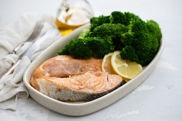 salmon with broccoli in dish on ceramic background