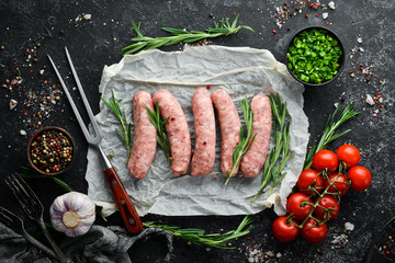 Raw barbecue sausages with spices and vegetables. Top view. Free space for your text.