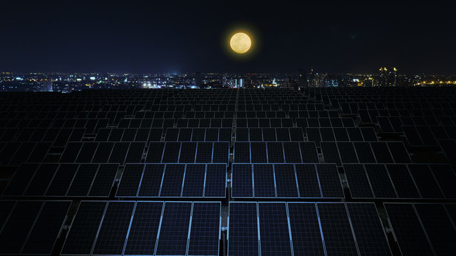 Solar Panels At Night With Full Moon And City Background.