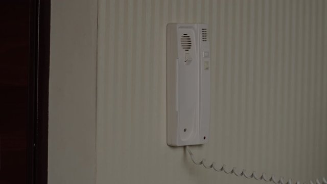 Woman answers the intercom call, opens the door