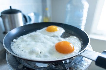 2 scrambled eggs on the pan. On the gas cylinder. Close up.