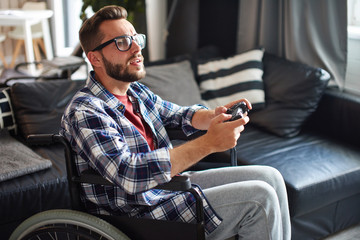 Man in wheelchair playing video games at home