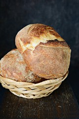 Homemade Freshly Baked Country Bread  made from wheat and whole grain flour on a dark background. French Freshly baked bread. Slicing homemade bread 