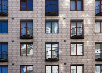 Fototapeta premium Brick facade modern building with semicircular balconies front view