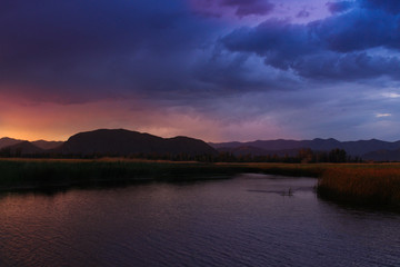 stunningly beautiful sunset with bright colors on a lake in Kyrgyzstan. Travel and nature