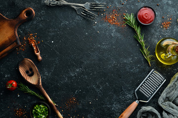 Dark cooking banner. Vegetables and spices on the kitchen table. Top view. Free space for your text.