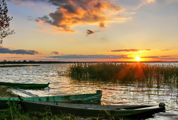 wooden boats near the shore at sunset