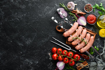 Raw Pork sausages with rosemary and vegetables. Top view. Free space for your text.