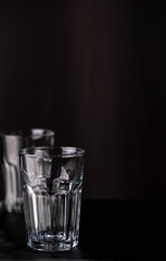 Two empty cocktail glasses on a dark background with copy space for text.