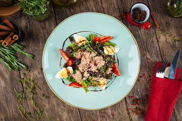 Gourmet tuna salad with eggs greens and sauce