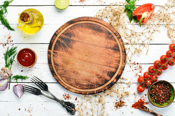 Food banner. Spices, vegetables and herbs on a white wooden background. Top view. free space for...