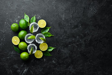 Tequila salt and lime. Alcohol. On a black stone background. Top view. Free space for your text.
