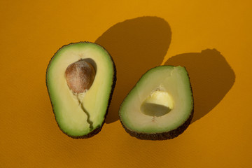 sliced avocado close up isolated on yellow background