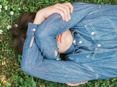 angry young man lying on the grass