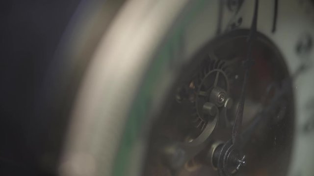 Macro shot of an antique vintage clock with a detailed depiction of the clock face, hands of the clock, cogwheel and pendulum. 