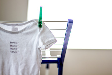 Happy day every day - concept for love at home with baby shirt hanging on clothes horse (no people)