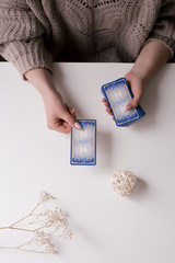 woman with tarot cards in her hands on the white table
