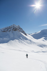 one women snowshoeing towards Valbellhorn mountain in winter landscape