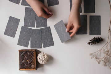 woman hands with tarot cards on the white table