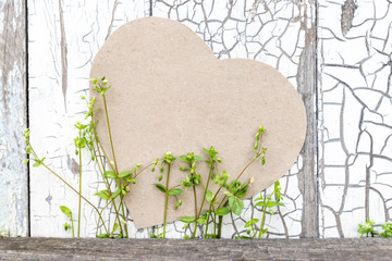 Paper heart and flowers on a background of a rustic wall as a symbol of love