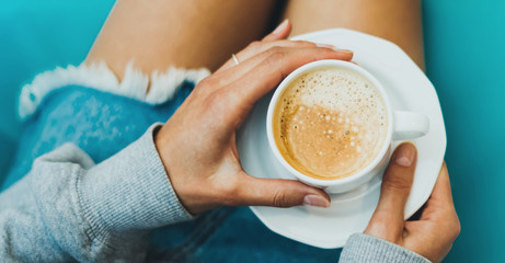 isolation woman holding in female hands cup of coffee at home, homemade drink cuppuccino in breakfast time in house, hipster traveler girl in the morning sun day, holiday relax, top view blur