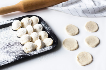 raw dumplings lie on a tray, near tortillas, sculpt dumplings, Russian national cuisine