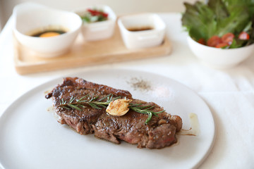beef steak with salad on white table