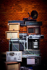 Tower built from old disused analog radios, amplifiers, cassette recorders and a phonograph. Old...