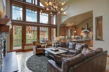 Amazing two story tall living room interior  with sky bridge and leather furniture.