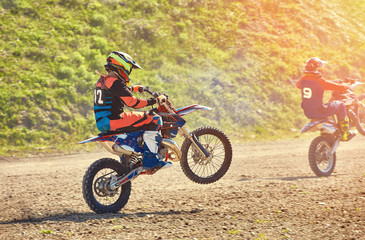 A team of mountain bike athletes starts, smoke and dust fly out from under the wheels off-road. Motocross outdoor activity concept.