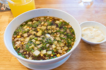 Potato soup with green onions and sour cream on the table