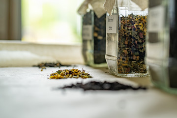 Jars with three types tea on table, alternative medicine and natural food. Side view