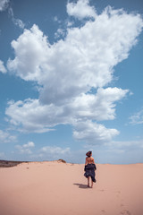 Beautiful girl in black swimsuit in the desert