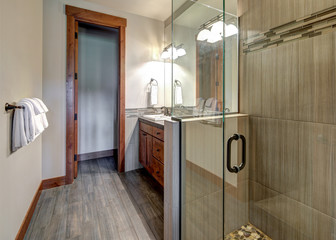 New rustic luxury home bathroom for guest design details with rich wood and grey stone.