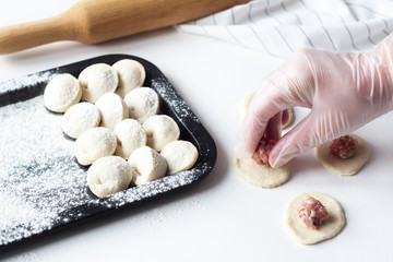 sculpt dumplings. woman puts meat on tortillas