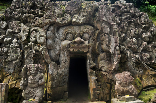 Ancient sculpture carving gate entrance tunnel of Goa Gajah or Elephant Cave significant Hindu archaeological site for travelers people travel visit and respect praying at Ubud city in Bali, Indonesia